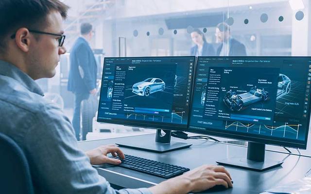 Mann sitzt vor zwei Computer-Bildschirmen und bearbeitet 3D-Grafiken