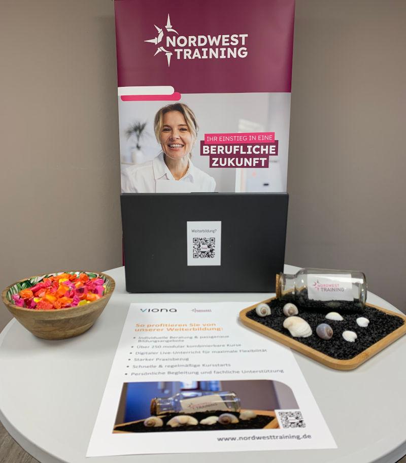 Einladender kleiner Tisch mit Aufsteller, Süßigkeiten und Deko bei Nordwest Training.